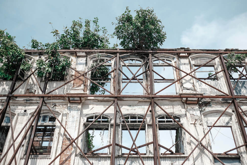 low-angle-view-abandoned-building-against-blue-sky